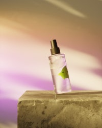 a bottle of perfume sitting on top of a stone wall